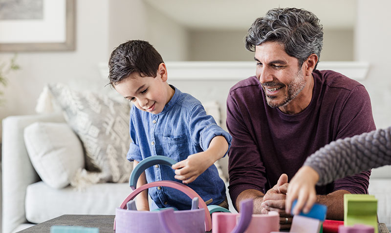 Father and son in living playing with toys